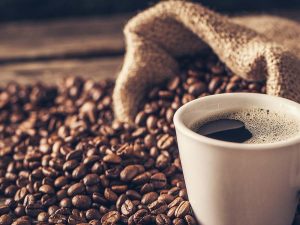 cup of coffee surrounded by beans