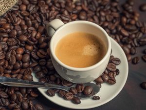 top view of espresso surrounded by coffee beans